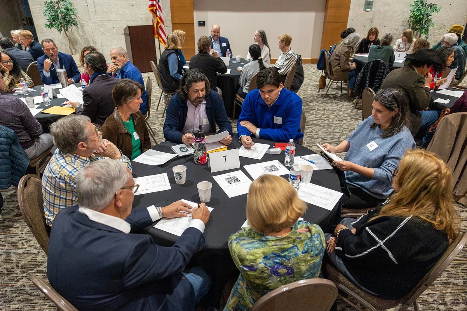 People in conversation around a shared table at a Bringing Houston Together event